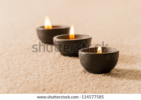 Spa therapy three candles on sand still nature