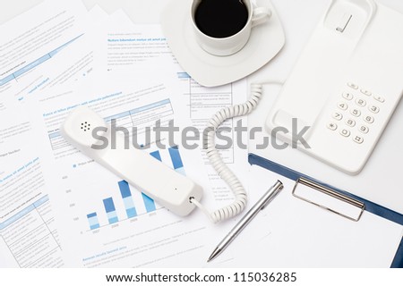 Busy office desk telephone on paper charts business meeting