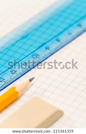 School geometry supplies pencil, rubber and ruler on square paper