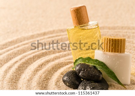 Spa therapy cosmetic products with zen stones on sand