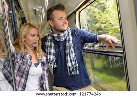 Couple looking out the train window smiling woman man vacation