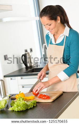 Happy woman cutting tomato kitchen vegetables preparing salad food