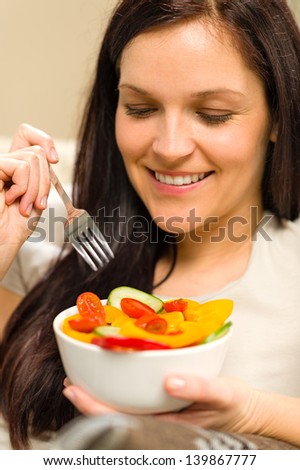 Cute happy woman eating fresh bowl of vegetables