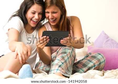 Best friends laughing loudly browsing social network