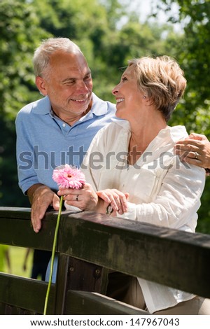 Romantic senior couple laughing at each other outdoors