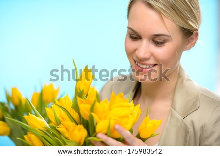 Woman looking down spring yellow flowers hold bouquet of tulip