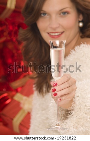 Beautiful lady toasting with a champagne glass in front of pile of gifts