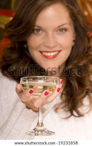 Portrait of beautiful lady toasting with a coupe of champagne, blurred background