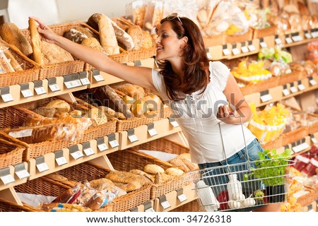 Grocery store: Young woman holding shopping basket and choosing bread