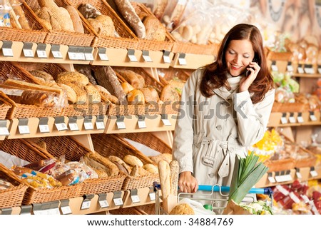Grocery store: Young brown hair woman with mobile phone and shopping cart