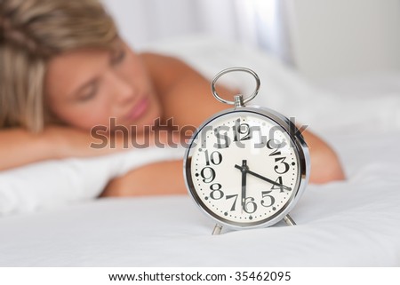 Silver alarm clock, woman in background unsharp