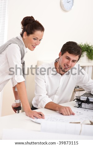 Young man and woman working together at the office