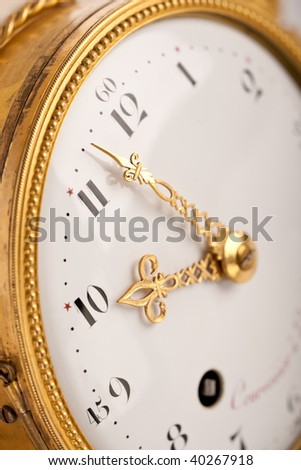 Close-up of antique gold clock with Arabic numeral, macro lens