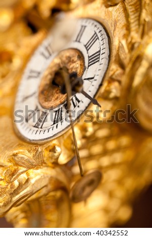 Close-up of antique gold clock with Roman numeral, macro lens