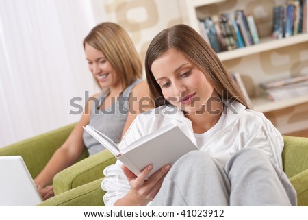 Students - Two female students studying in living room reading book