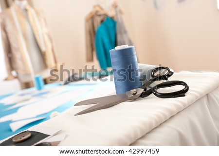 Fashion designer studio with professional equipment, sketches, mannequin, cloth