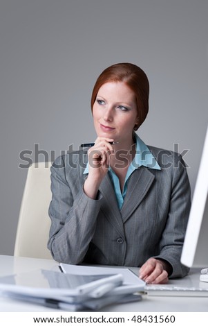 Successful business woman at office thinking sitting at computer