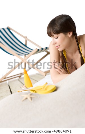 Beach - Attractive woman in bikini relaxing, deck-chair in in background