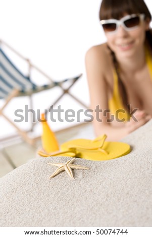 Beach - starfish on sand, woman in bikini with flip-flop out of focus