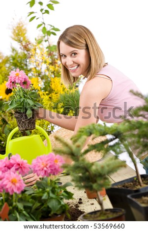 Gardening - Happy woman holding flower pot with blossoming flower on white background