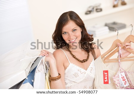 Fashion shopping - Happy woman choose sale clothes, holding shopping bag