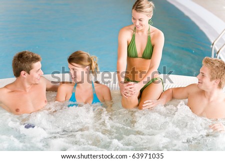 Swimming pool - young happy people relax in hot tub