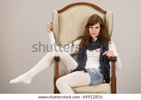 Hispanic fashion model posing on antique armchair