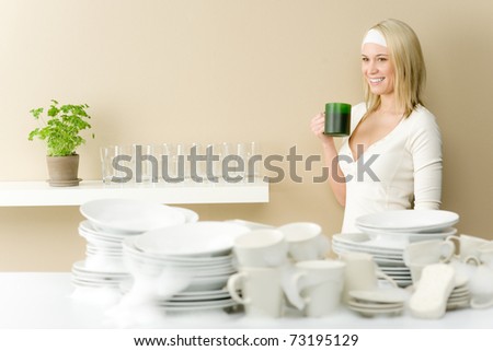 Modern kitchen - happy woman washing dishes having coffee break