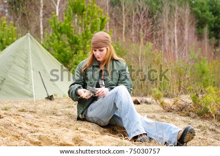 Camping happy woman tent nature cut stick sitting by stream