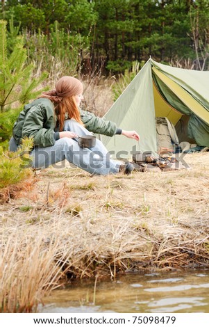 Camping happy woman cook food fire tent nature water stream