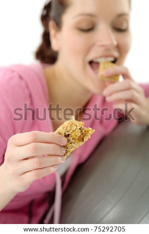 Fitness woman eat cereal bar sportive outfit in gym