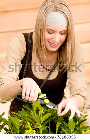 Gardening woman pruning plants in spring on terrace