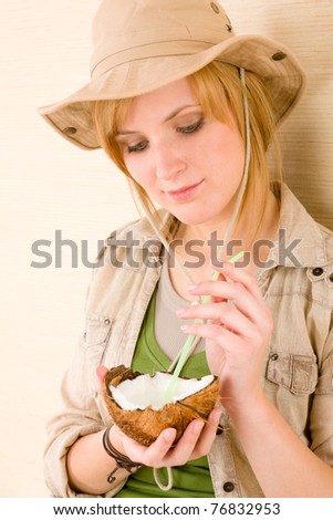 Safari young woman drink with straw from coconut