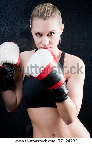 Blond training boxing woman with gloves in gym