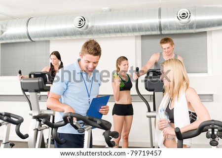 Young fitness instructor with gym people