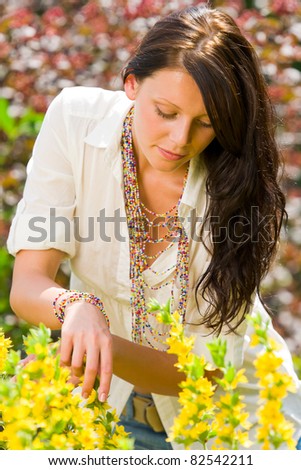 Beautiful young woman sunny garden care yellow flower portrait