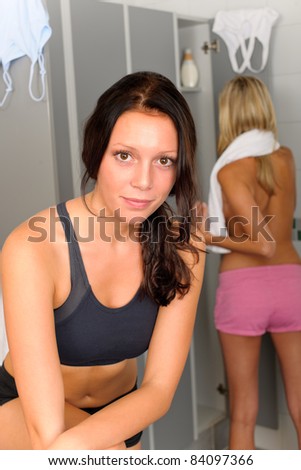Locker room two sportive women getting ready for fitness training shower
