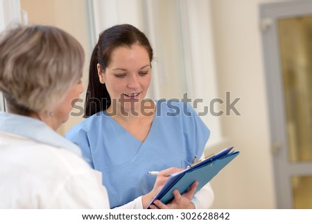 Two female doctors looking at patient files