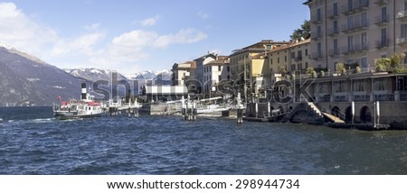 Bellagio lake of Como, Italy - April 1, 2015: Dock of Bellagio with nineteenth-century historic homes. A passenger boat service on the lake approaching tourist boarding.