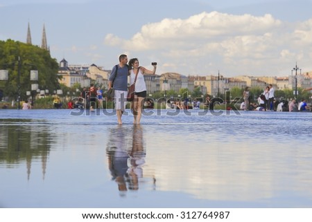 BORDEAUX, FRANCE - 4 August, 2015 : Bordeaux water mirror full of people in one of the hotest summer days, having fun in the water, the pool is the largest water mirror in the world with 3450 sq.m.