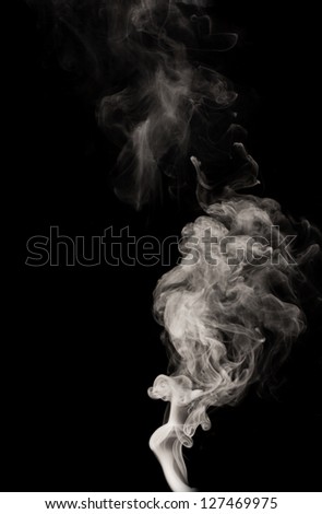 Abstract black smoke swirls over the black background