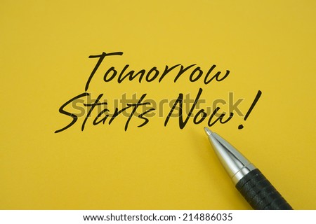 Tomorrow Starts Now! note with pen on yellow background