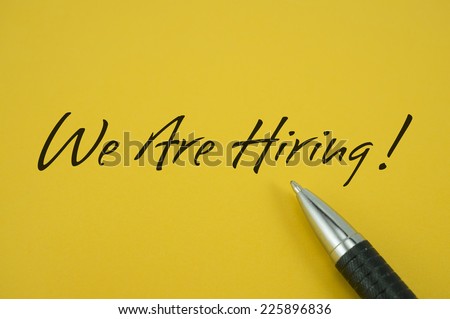 We Are Hiring! note with pen on yellow background