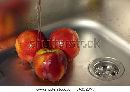 Washing nectarines in stainless steel sink