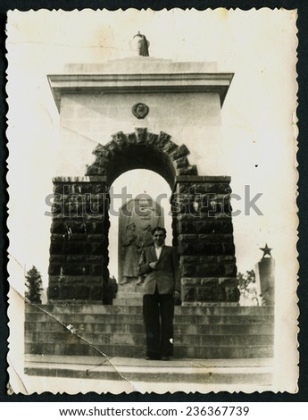 USSR - CIRCA 1960s: An antique photo shows man on the background of the monument to the soldiers, USSR, circa 1960s