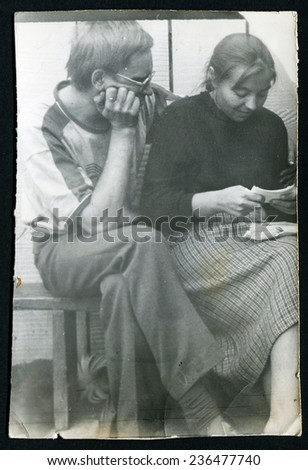 Ussr - CIRCA 1980s: An antique Black & White photo show man and woman sitting on a bench and reading letters