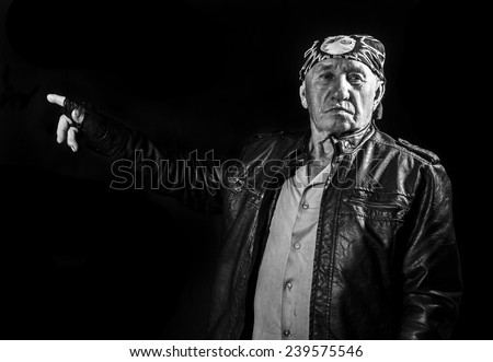 Portrait of an old man biker pointing finger