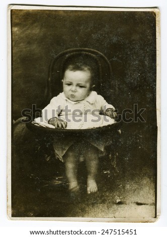 Ussr - CIRCA 1940s: An antique Black & White photo show little baby on the chair