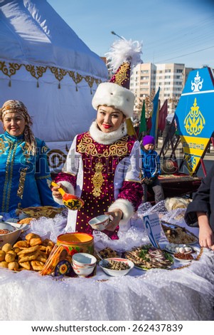 PETROPAVLOVSK, KAZAKHSTAN - MARCH 21, 2015: celebration of the new year on the solar calendar astronomical in Iranian and Turkic peoples. Kazakh girl pours mare