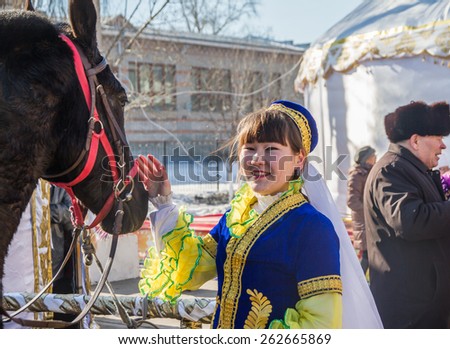 PETROPAVLOVSK, KAZAKHSTAN - MARCH 21, 2015: celebration of the new year on the solar calendar astronomical in Iranian and Turkic peoples. The girl stroking horse